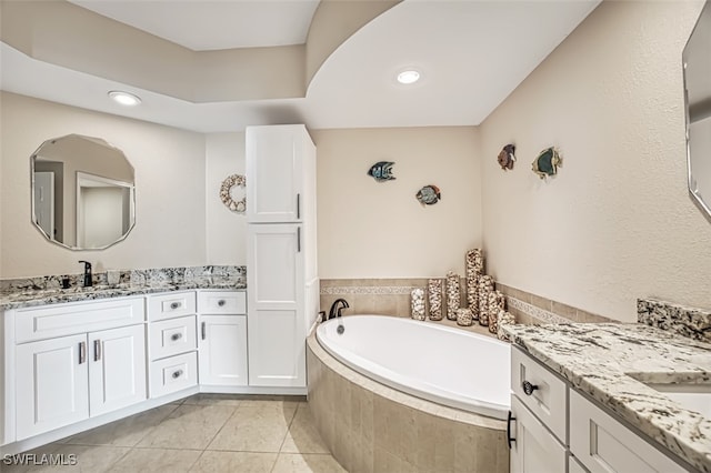 bathroom with vanity, tiled bath, and tile patterned floors