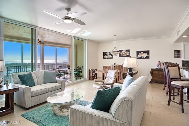 living room featuring a water view, ceiling fan, ornamental molding, light tile patterned flooring, and a wall of windows