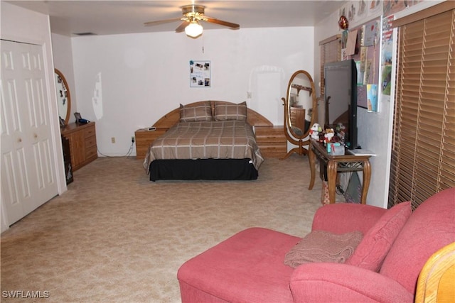 bedroom with ceiling fan, light colored carpet, and a closet