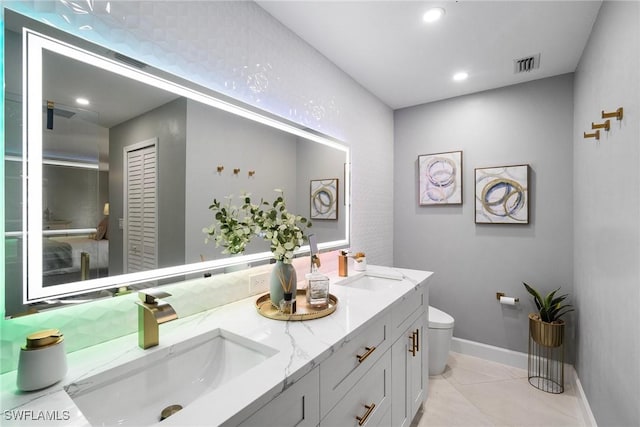 full bath with double vanity, recessed lighting, visible vents, toilet, and a sink