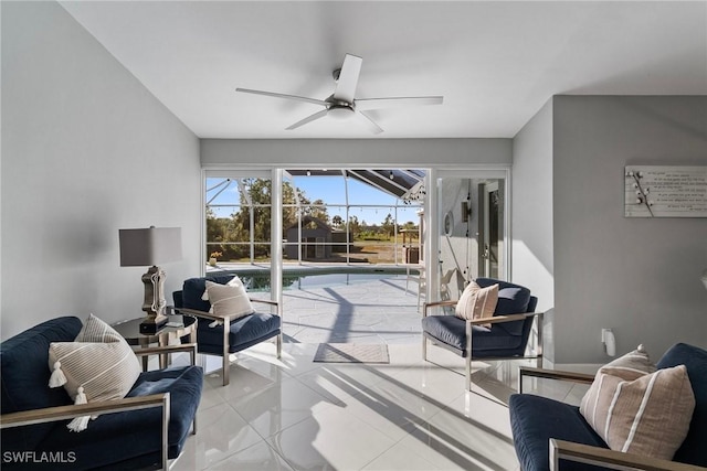 living area with a ceiling fan, a sunroom, and tile patterned floors