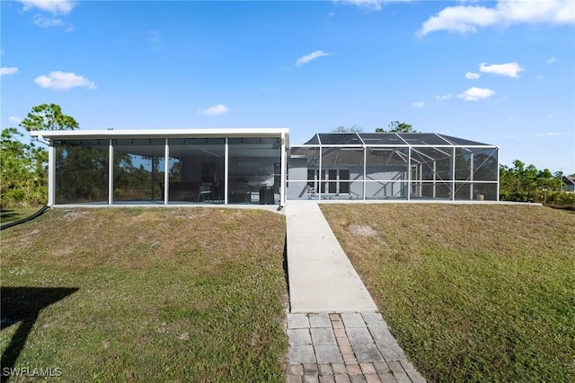 back of property with a yard and a lanai