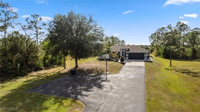 view of front facade with driveway, an attached garage, and a front lawn