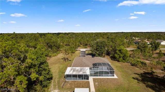 drone / aerial view with a wooded view