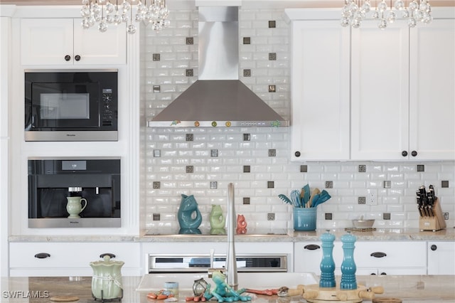 kitchen with white cabinets, oven, wall chimney range hood, and built in microwave