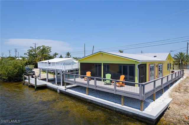 back of property featuring a sunroom and a water view