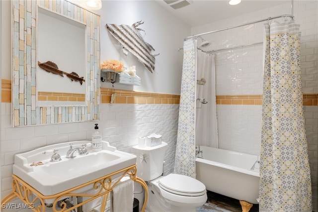 full bathroom with sink, shower / tub combo with curtain, tile walls, and toilet