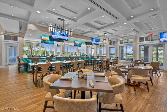 dining space with beam ceiling, light hardwood / wood-style flooring, and coffered ceiling