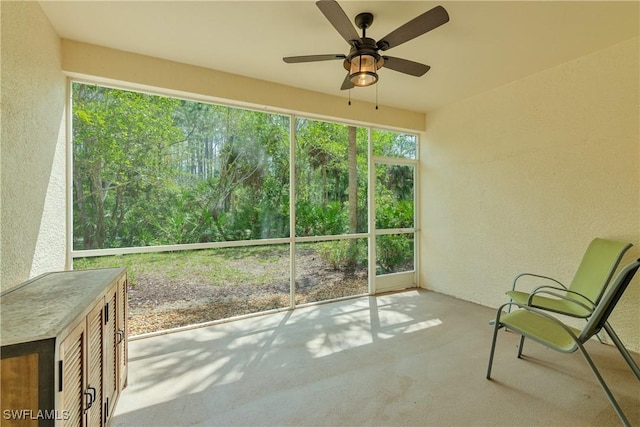 unfurnished sunroom with ceiling fan