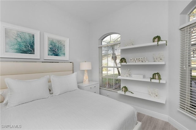 bedroom with light hardwood / wood-style flooring and multiple windows