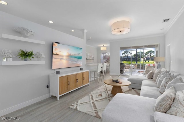 living room featuring light wood-type flooring and crown molding