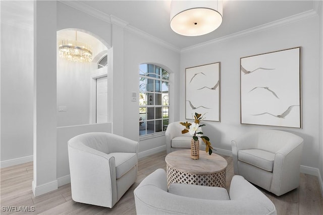 sitting room with hardwood / wood-style floors, a notable chandelier, and crown molding