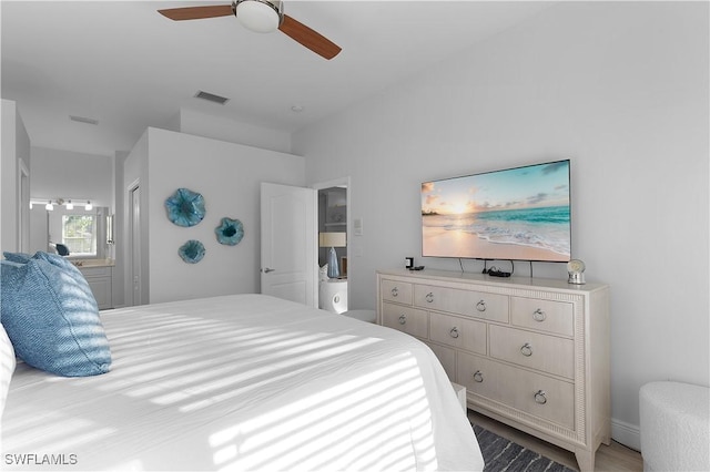 bedroom with ceiling fan, ensuite bathroom, and hardwood / wood-style flooring