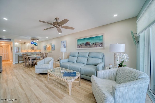 living room featuring light hardwood / wood-style floors and ceiling fan