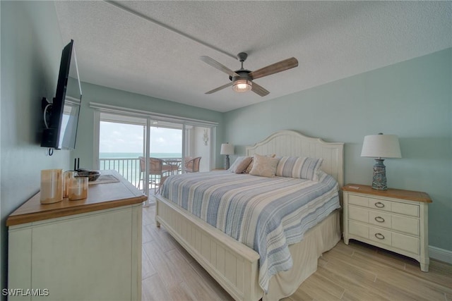 bedroom with access to exterior, ceiling fan, light hardwood / wood-style flooring, and a textured ceiling