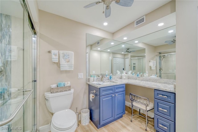 bathroom featuring ceiling fan, walk in shower, wood-type flooring, toilet, and vanity