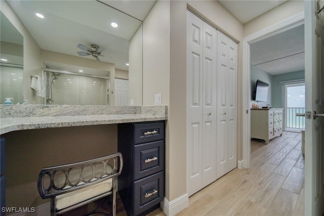 bathroom featuring ceiling fan, an enclosed shower, wood-type flooring, and vanity