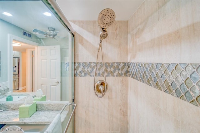 bathroom with vanity, ceiling fan, and a tile shower