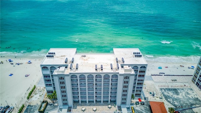 drone / aerial view with a water view and a beach view