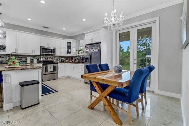 kitchen featuring dark stone countertops, pendant lighting, white cabinets, and stainless steel appliances