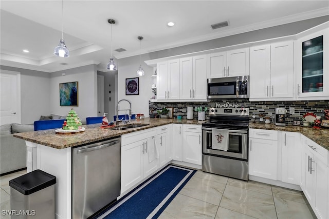 kitchen with pendant lighting, white cabinets, crown molding, and appliances with stainless steel finishes