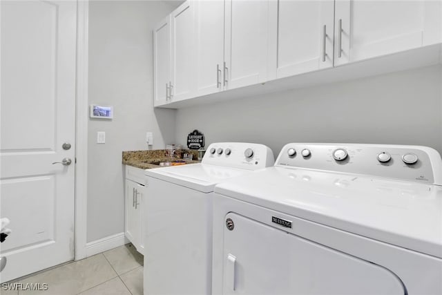 laundry area with cabinets, sink, light tile patterned flooring, and washer and dryer