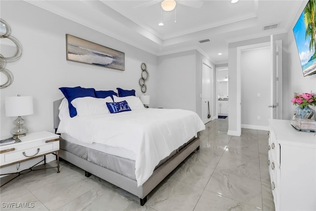 bedroom with ceiling fan, a raised ceiling, ornamental molding, and ensuite bathroom