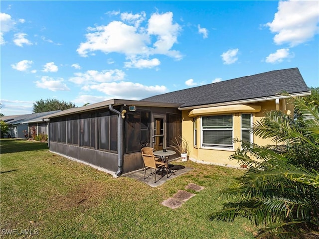 back of property featuring a patio, a lawn, and a sunroom