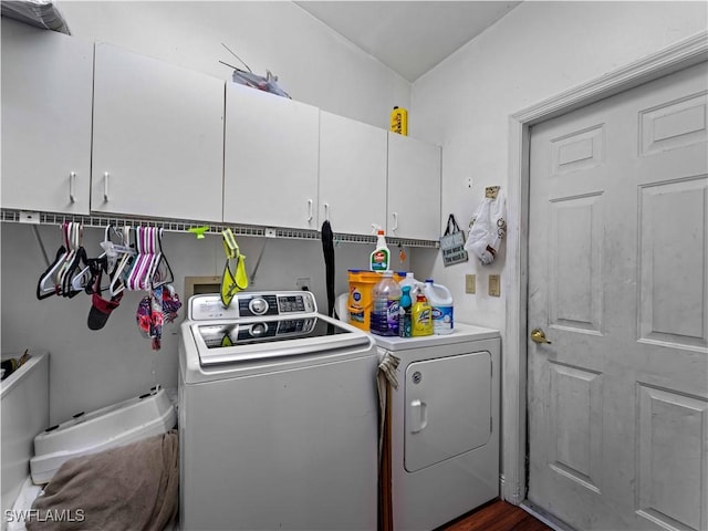 laundry room featuring washer and dryer, dark hardwood / wood-style flooring, and cabinets