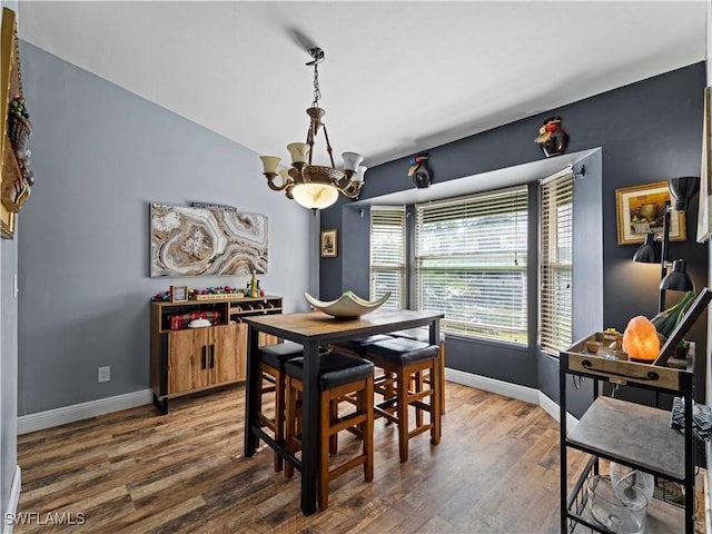 dining room with hardwood / wood-style floors and a notable chandelier