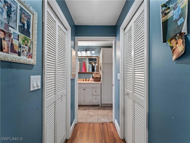 hall with light wood-type flooring and sink