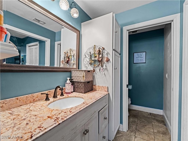 bathroom featuring tile patterned flooring, vanity, and toilet