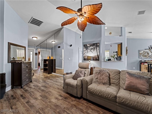 living room with ceiling fan, high vaulted ceiling, and dark wood-type flooring