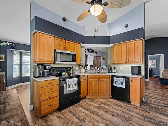 kitchen with sink, hardwood / wood-style flooring, lofted ceiling, and black appliances