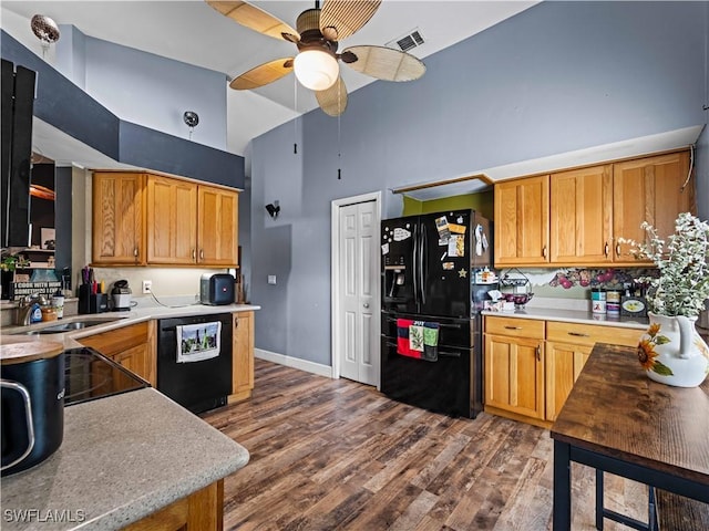 kitchen featuring dark hardwood / wood-style flooring, a towering ceiling, ceiling fan, sink, and black appliances