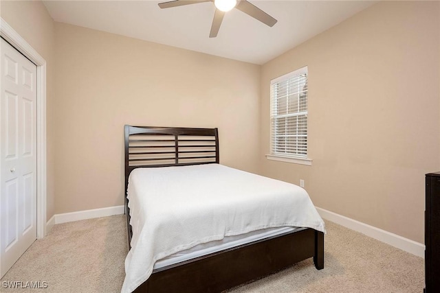 bedroom with a closet, ceiling fan, and light colored carpet