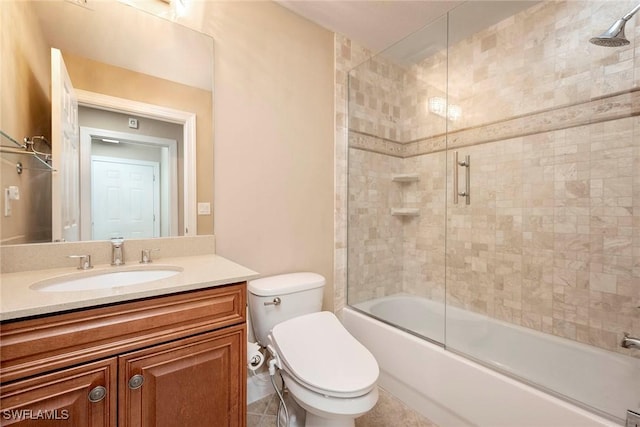 full bathroom with tile patterned floors, vanity, toilet, and bath / shower combo with glass door