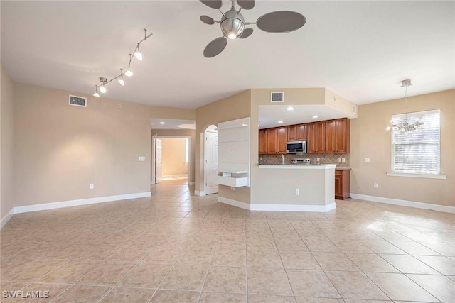 kitchen with a chandelier, light tile patterned floors, backsplash, and hanging light fixtures