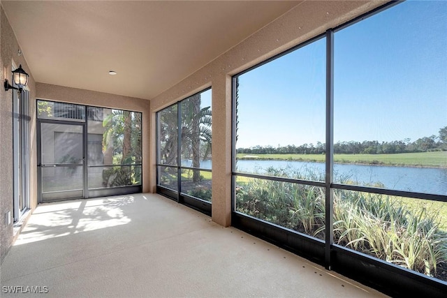 unfurnished sunroom featuring a water view