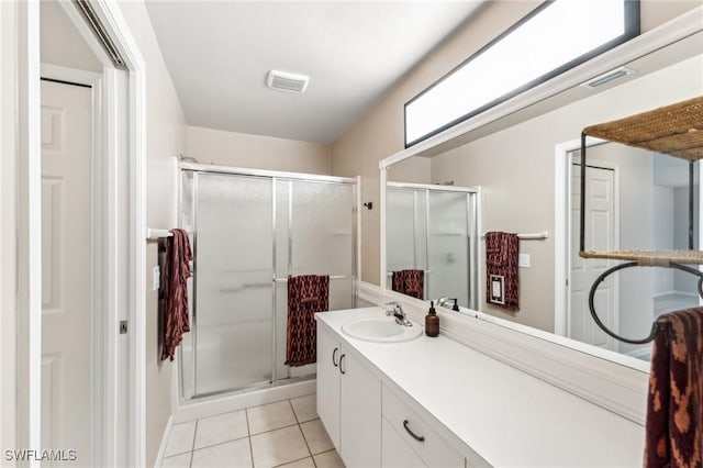 bathroom featuring tile patterned flooring, vanity, and walk in shower