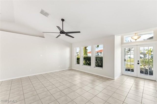 tiled empty room featuring ceiling fan, french doors, and lofted ceiling