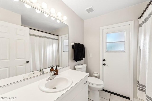 bathroom with tile patterned flooring, vanity, and toilet