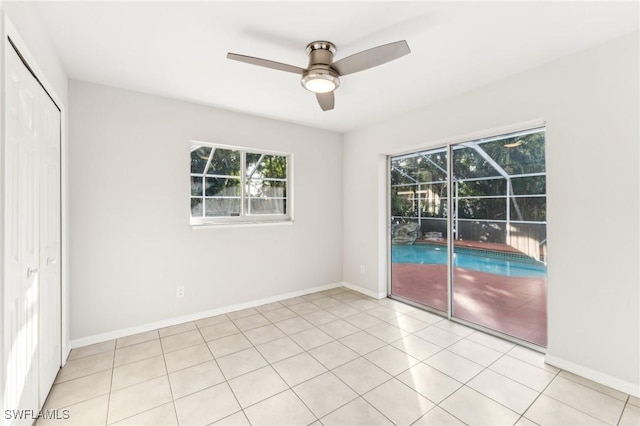 tiled spare room with ceiling fan