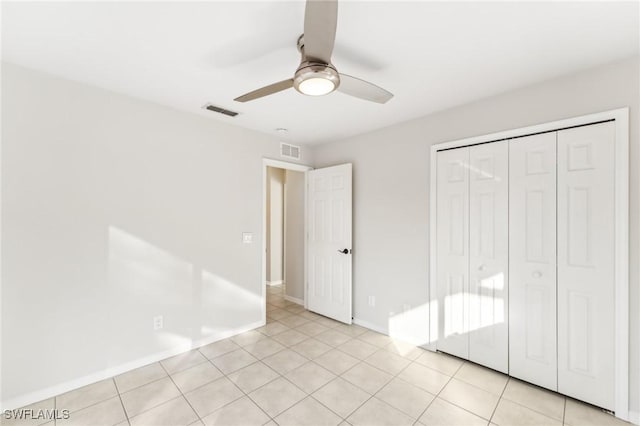 unfurnished bedroom featuring ceiling fan, a closet, and light tile patterned floors