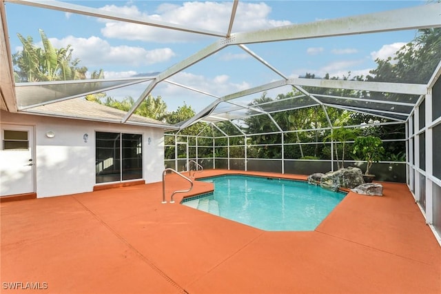 view of pool featuring glass enclosure and a patio area