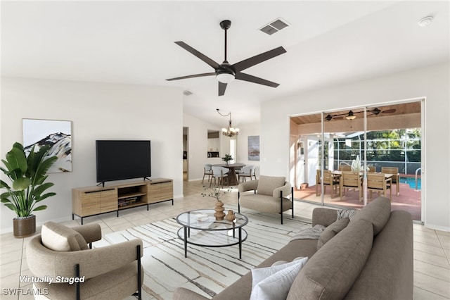 tiled living room with ceiling fan with notable chandelier and lofted ceiling