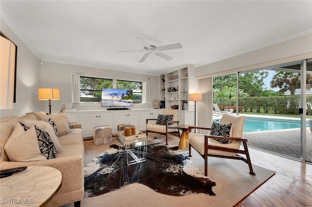 living room with ceiling fan, light wood-type flooring, and crown molding