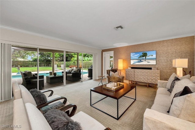 living room with plenty of natural light, light colored carpet, and ornamental molding