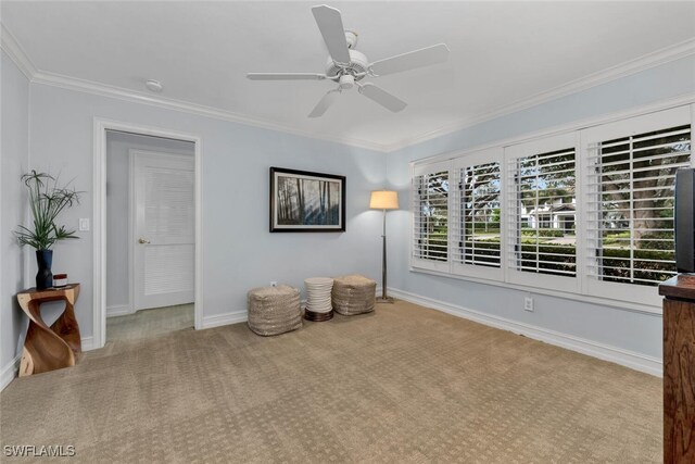 unfurnished room featuring ceiling fan, light colored carpet, and crown molding