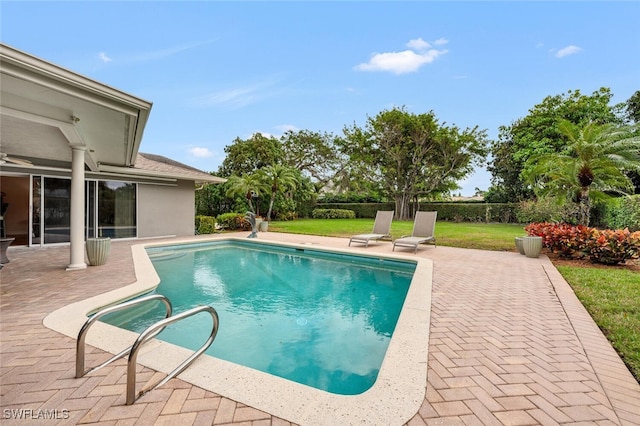 view of swimming pool featuring a lawn and a patio